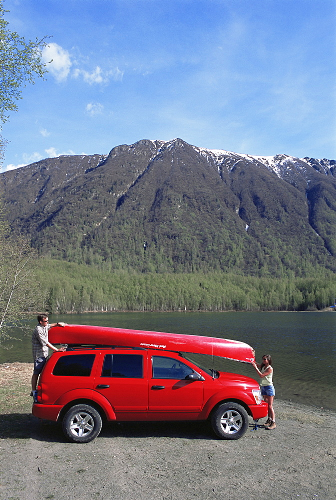 Couple unloading canoe at Mirror Lake, off Seward Highway, Chugach Mountain Range, Bear Mountain, Anchorage, Alaska, United States of America, North America