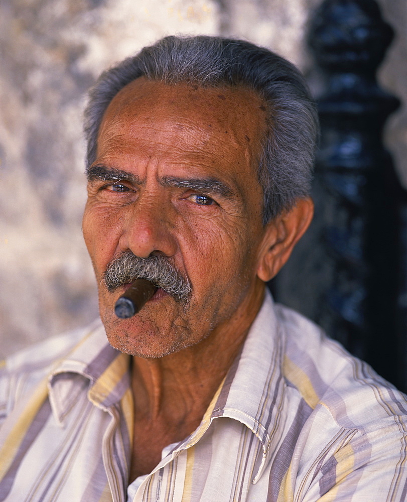 Head and shoulders portrait of an eldery man with moustache smoking a cigar, looking at the camera, Habana (Havana), Cuba, West Indies, Caribbean, Central America