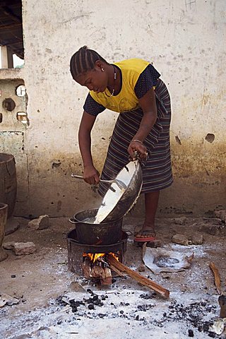 Portrait of a woman cooking outdoors over a small fire, Gambia, West Africa, Africa