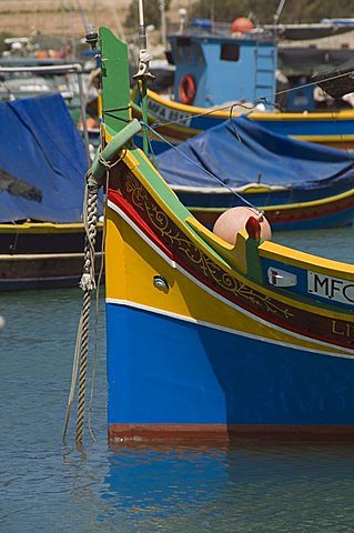 Brightly coloured fishing boats called Luzzus with the eye of Osiris to ward off evil at Marsaxlokk, a fishing village, Malta, Mediterranean, Europe