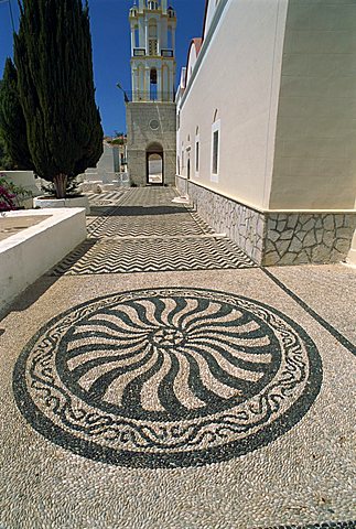 Design in cobbled pavement by St. Nicholas church, Chalki (Halki), Dodecanese, Greek Islands, Greece, Europe