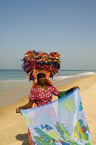 Local vendor selling beach clothing on beach near the Leela Hotel, Mobor, Goa, India, Asia