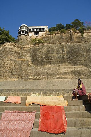 Drying washing with Ahilya Fort behind, now a heritage hotel, on the banks of the Narmada River, Maheshwar, Madhya Pradesh state, India, Asia