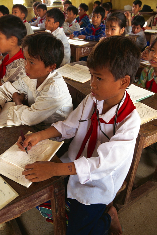 Portrait of children in school uniform sitting at desks in a school classroom in North Vietnam, Indochina, Southeast Asia, Asia