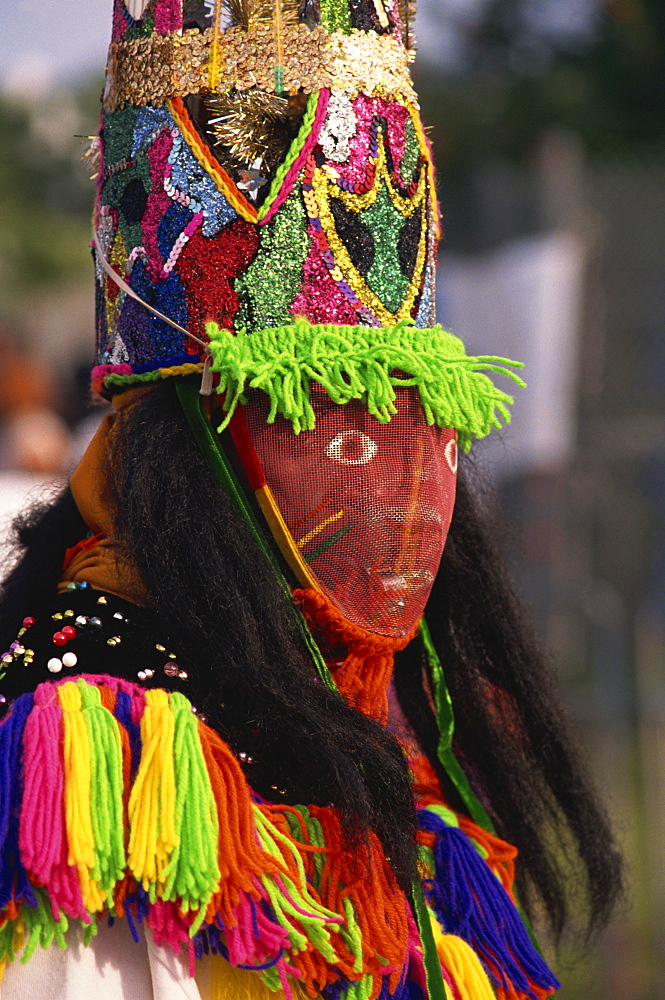 Head and shoulders portrait of a person wearing mask headdress and brightly coloured costume, Gombey, island of Bermuda, Atlantic, Central America