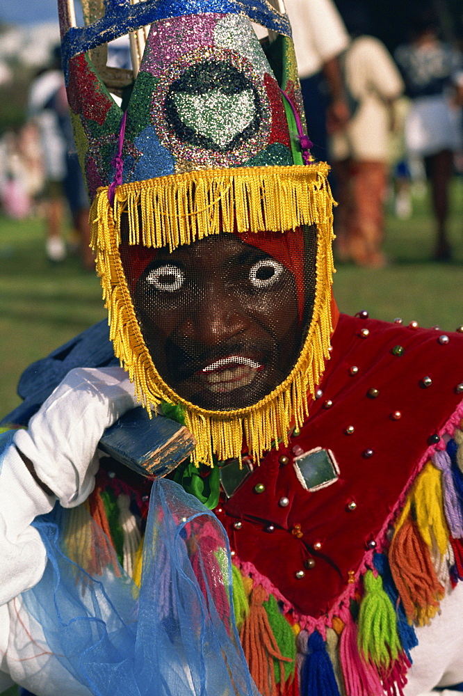 Head and shoulders portrait of a person wearing mask headdress and brightly coloured costume, Gombey, island of Bermuda, Atlantic, Central America