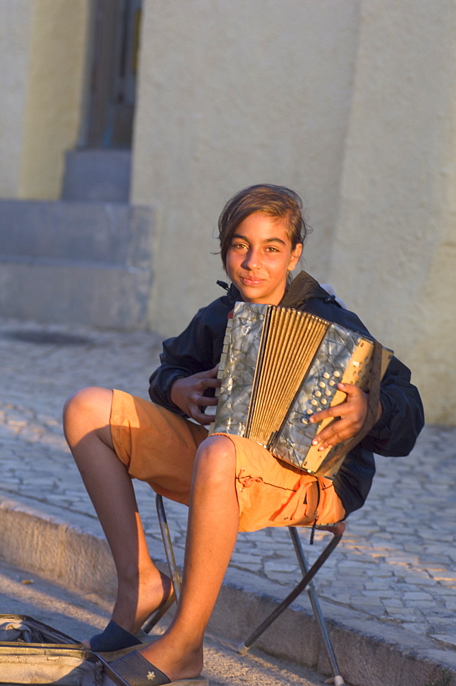 Gypsy girl playing piano accordion, Alvor, Algarve, Portugal, Europe