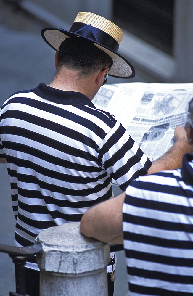 Gondolier reading newspaper, Venice, Veneto, Italy, Europe