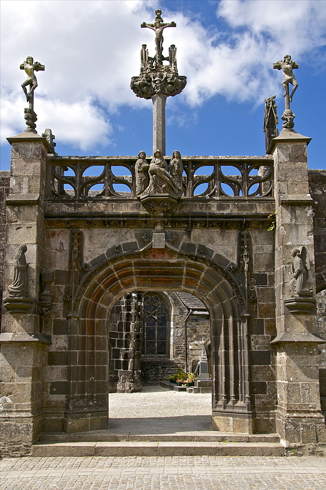 Monumental Gate, flamboyant 16th century style showing Christ on the cross flanked by the two thieves, La Martyre church enclosure, La Martyre, Finistere, Brittany, France, Europe