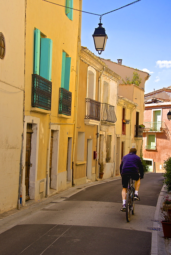 Street with cyclist, Old town, Bouzigues, Thau basin, Herault, Languedoc, France, Europe