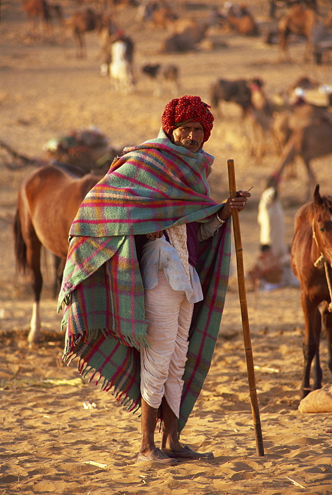 Portrait of an Indian farmer in traditional clothing, wearing turban and shawl, standing and looking at the camera, at Pushkar Camel Fair, Pushkar, Rajasthan, India, Asia