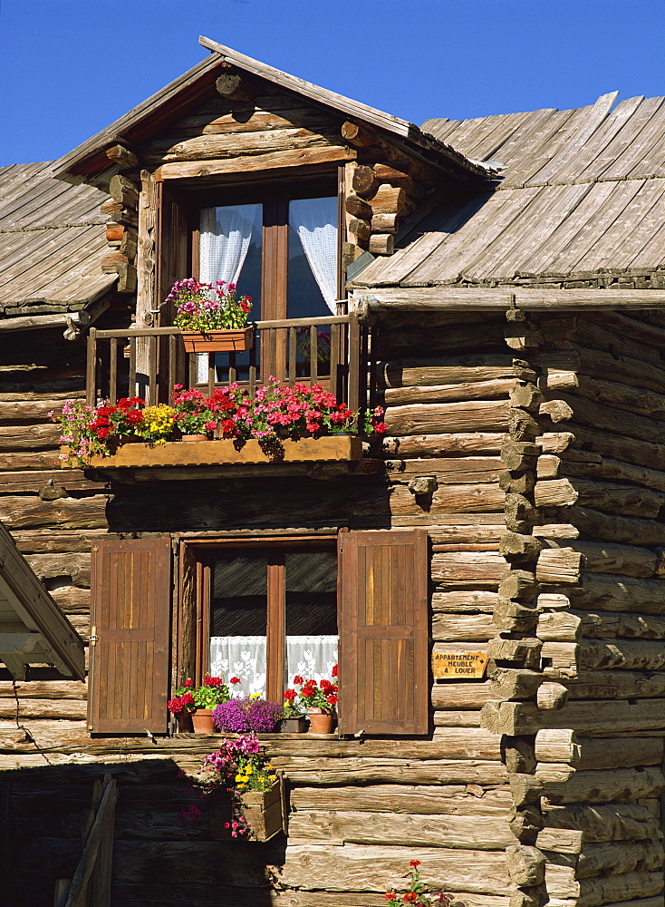 Close up of the exterior of a wooden house with window boxes in St. Veran in the Haute Alpes in Provence, France, Europe