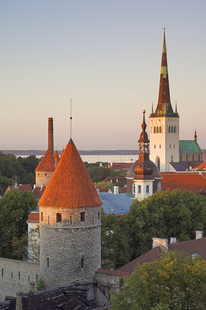 Medieval town walls and spire of St. Olav's church at dusk, Tallinn, Estonia, Baltic States, Europe