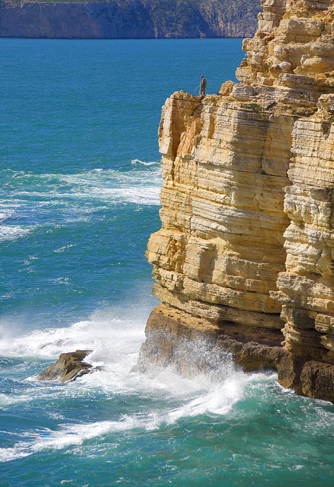 Fisherman on the edge of the cliff fishing on the Cape St. Vincent peninsula, Sagres, Algarve, Portugal, Europe