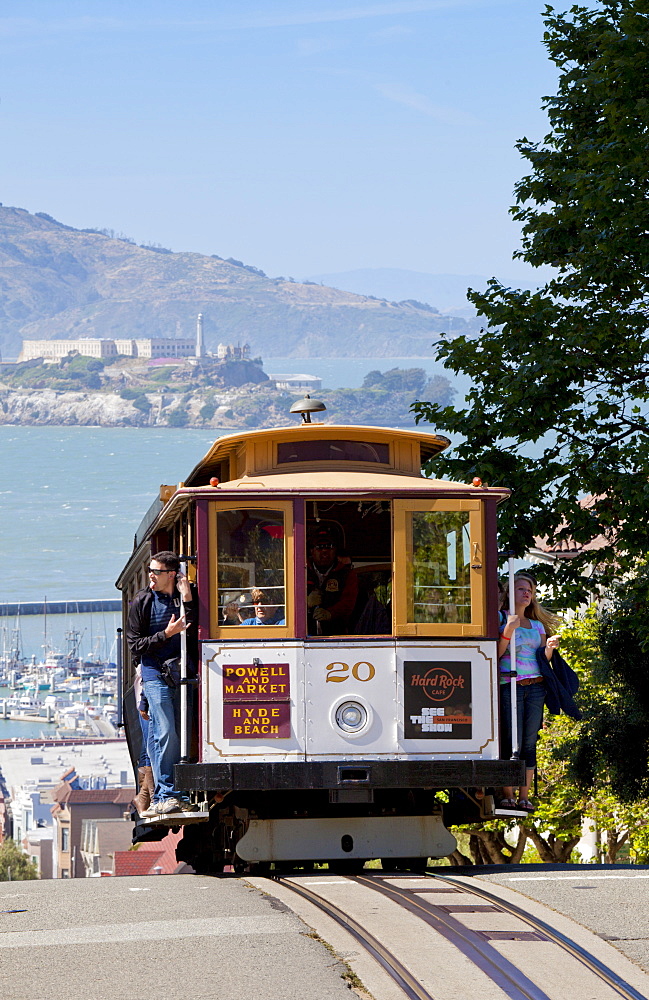 One of the famous cable cars on the Powell-Hyde track, with the island prison of Alcatraz in the background, San Francisco, California, United States of America, North America