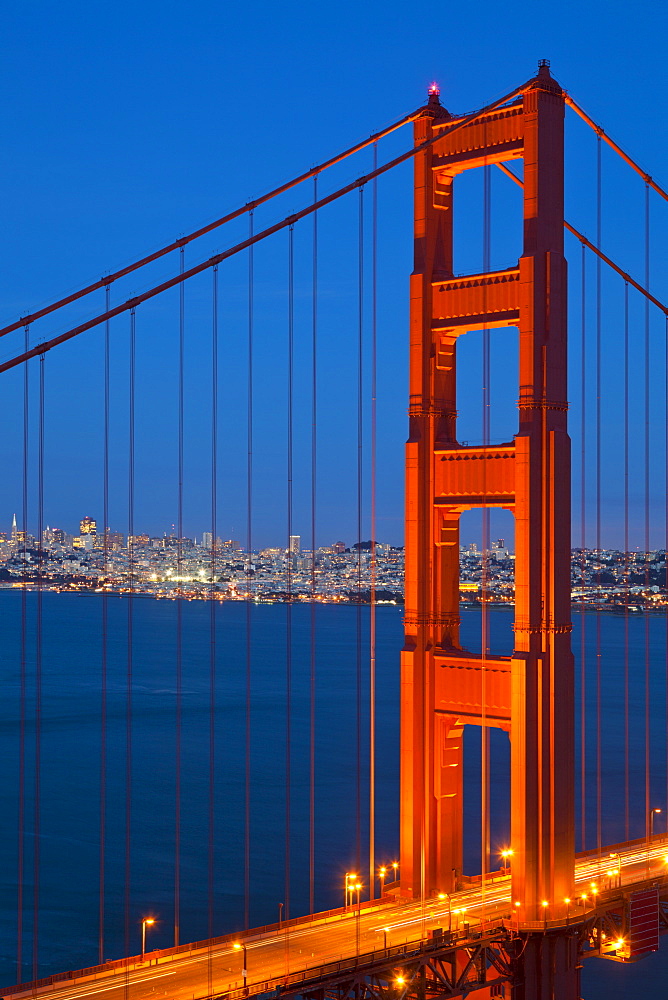 The Golden Gate Bridge, linking the city of San Francisco with Marin County, taken from the Marin Headlands at night with the city in the background and traffic light trails across the bridge, San Francisco, Marin County, California, United States of America, North America