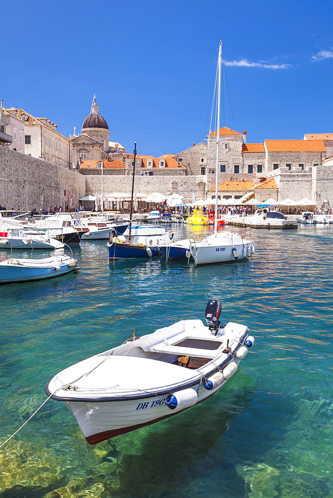 Fishing boat and clear water in the Old Port, Dubrovnik Old Town, Dalmatian Coast, Dubrovnik, Croatia, EU, Europe