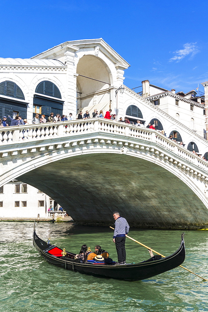 Venice gondola with tourists going under the Rialto bridge (Ponte del Rialto), Grand Canal, Venice, UNESCO World Heritage Site, Veneto, Italy, Europe