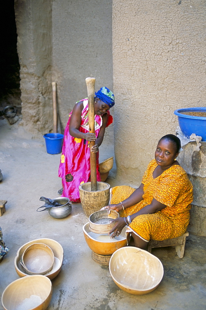 Women pounding grain, courtyard, Djenne, Mali, Africa