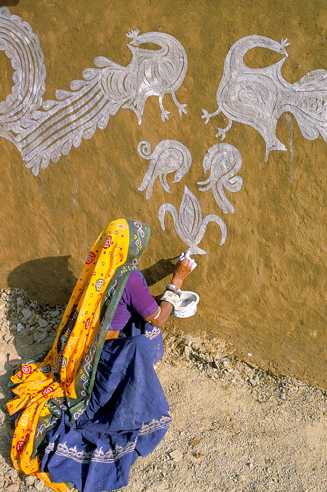 Woman painting designs on her house, Tonk region, Rajasthan state, India, Asia