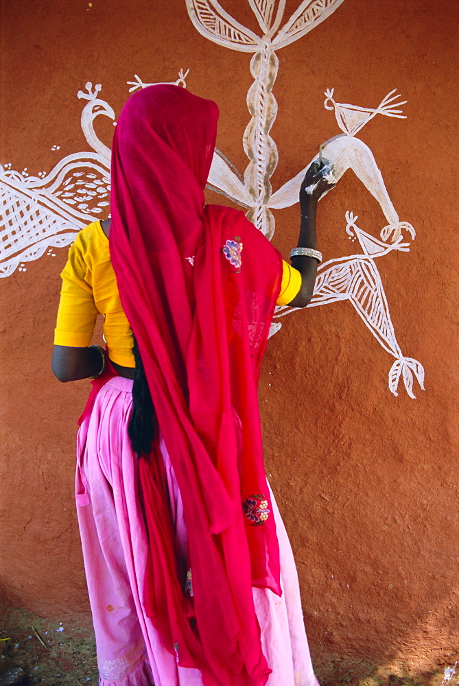 Woman decorating her house with traditional local designs, Tonk region, Rajasthan, India, Asia