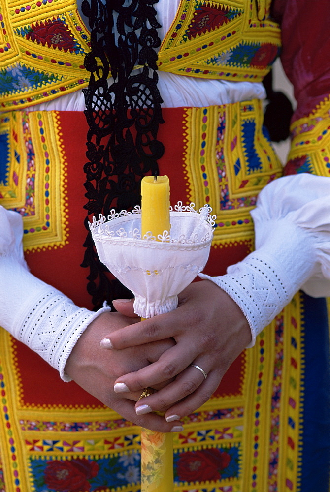 Close-up of woman holding a candle, Corpus Domini procession, Desulo (Gennargentu), Sardinia, Italy, Europe