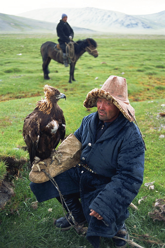 Portrait of an eagle breeder in traditional clothing, with his bird, Kazakh, Bayan-olgii, Khovd Gol valley, Mongolia, Central Asia, Asia