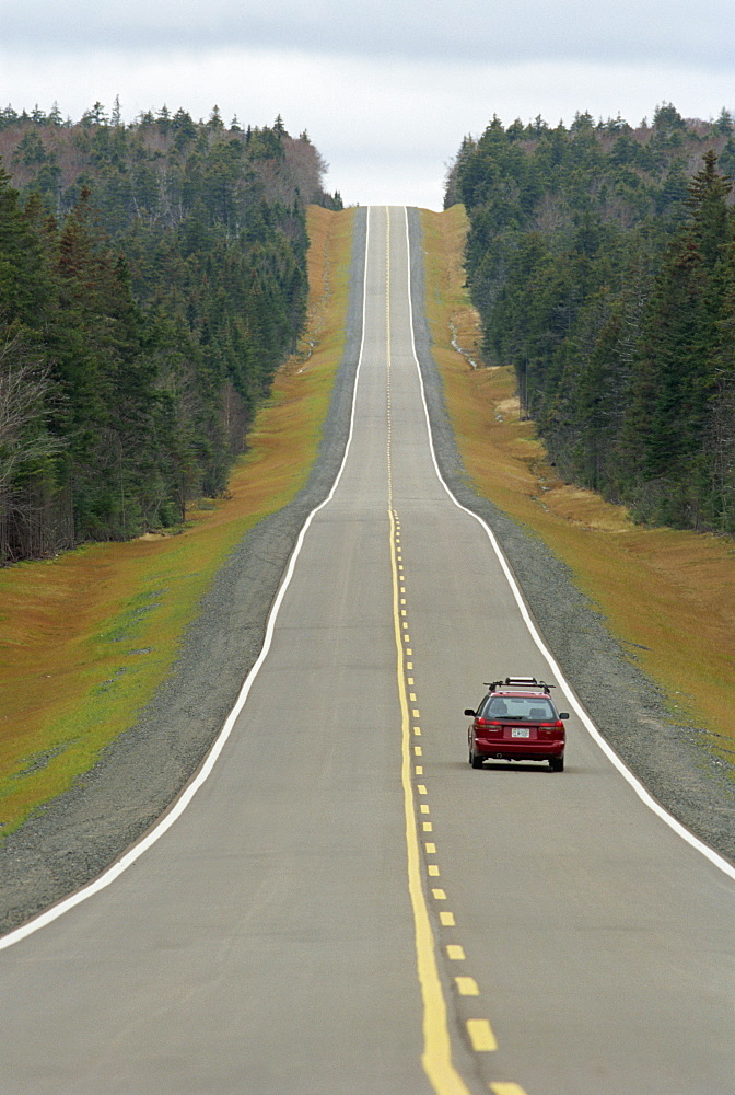 A single car on a straight road through the Kouchibouguac National Park, Atlantic Canada, New Brunswick, Canada, North America