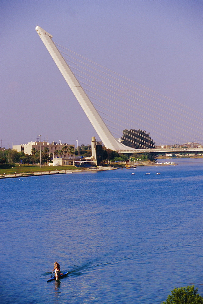 Man rowing with Barquetta  bridge in the background, Seville, Andalusia, Spain