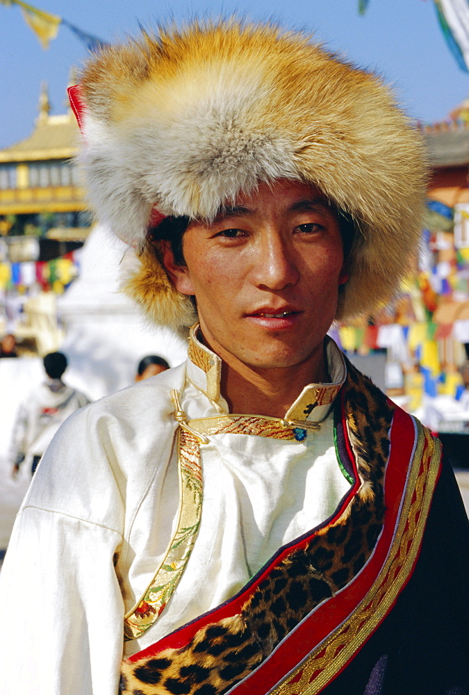 Young Tibetan man wearing typical hat and dress during Losar (Tibetan New Year) at Bodhnath, Katmandu, Nepal