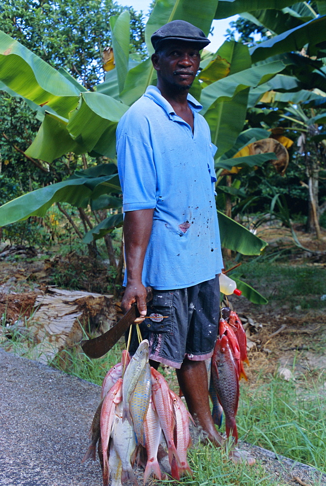 Portrait of a fisherman and his catch, near to Anse Possession, island of Praslin, Seychelles, Indian Ocean, Africa