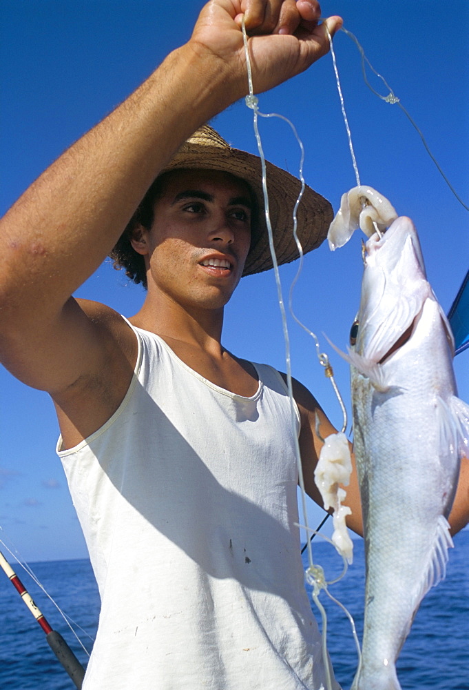 Fisherman and his catch, northeast coast, island of Praslin, Seychelles, Indian Ocean, Africa