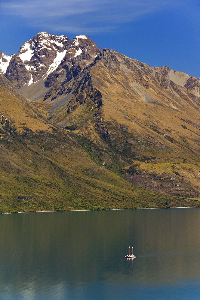 A tiny sail ship on the mountain edged Lake Wakatipu near Queenstown, Otago, South Island, New Zealand, Pacific