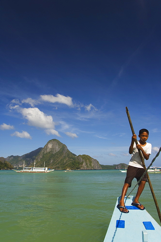 Young boy punting boat, Cadlao Island, Bacuit Bay, El Nido Town, Palawan Province, Philippines, Southeast Asia, Asia