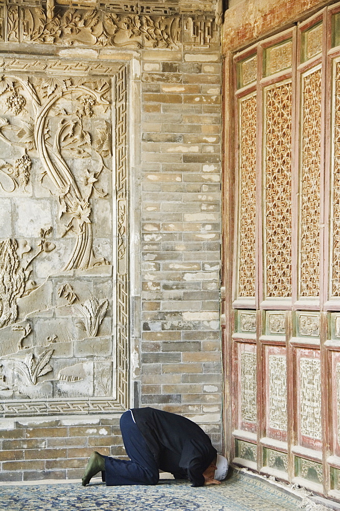 Man praying at The Great Mosque located in the Muslim Quarter, home to the citys Hui community, Xian City, Shaanxi Province, China, Asia