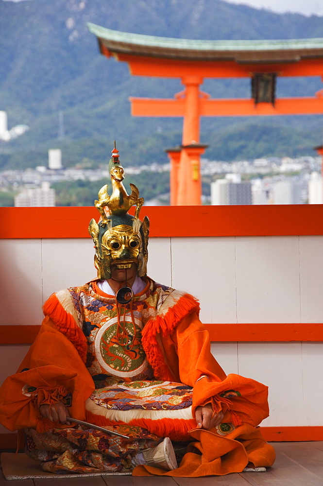 A Wedding Ceremony Dance Performer in front of the Floating Torii Gate at Itsukushima Shrine, founded in 593, UNESCO World Heritage Site, Miyajima Island, Hiroshima prefecture, Honshu Island, Japan, Asia