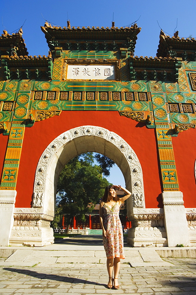 Chinese girl under a glazed archway at the Confucius Temple Imperial College, built in 1306 by the grandson of Kublai Khan, administering the official Confucian examination system, Beijing, China, Asia