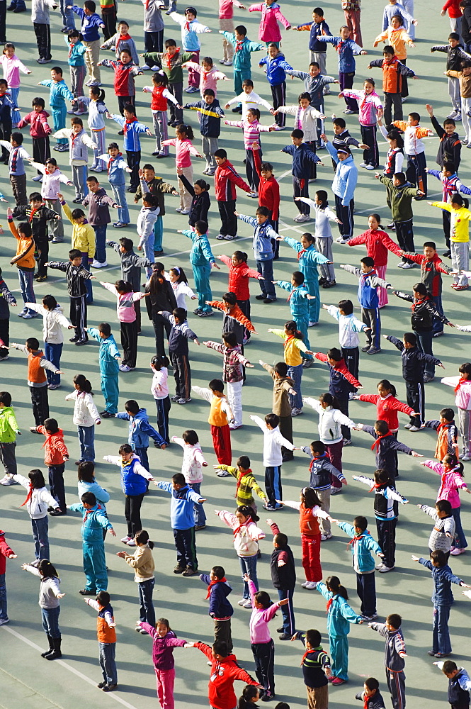 Junior school children exercising in colourful clothes, Beijing, China, Asia