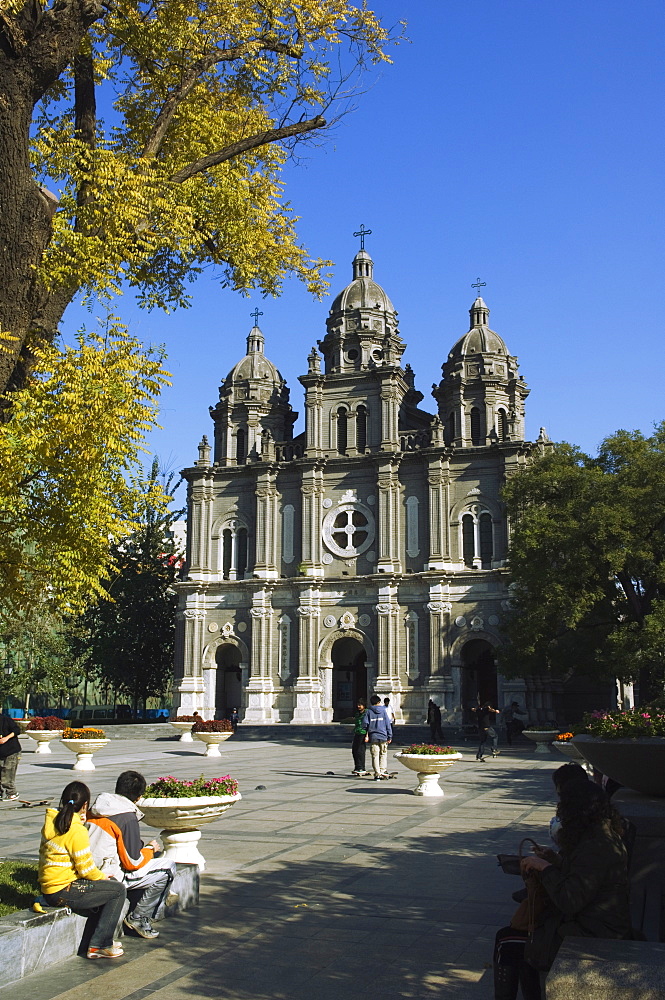 A couple sitting in front of St. Josephs Church (the East Church) built in 1655 during the reign of Shunzhi, Wangfujing Shopping Street, Beijing, China, Asia