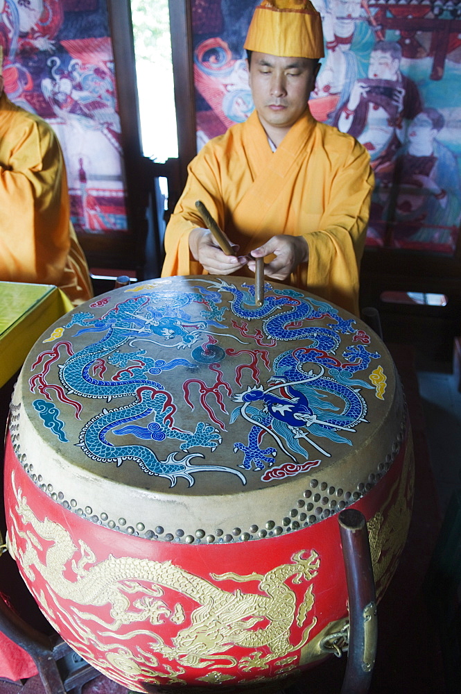 Musician playing a painted drum in Zhihua temple, a Ming Dynasty era Buddhist temple, Beijing, China, Asia