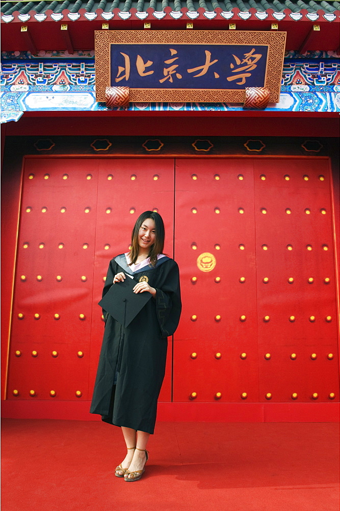 A female student on Graduation Day in front of a Chinese gate at Peking University, Beijing, China, Asia