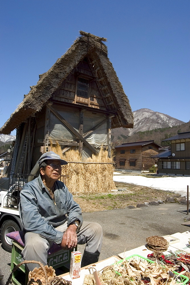 Man selling vegetables, gasshou zukuri thatched roof houses, Shirokawago, Ogimachi, Gifu prefecture, Honshu island, Japan, Asia