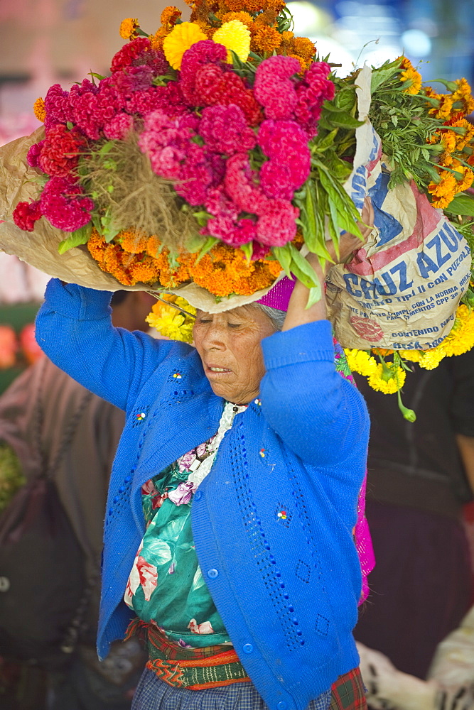 Woman carrying flowers at Tlacolula Sunday market, Oaxaca state, Mexico, North America