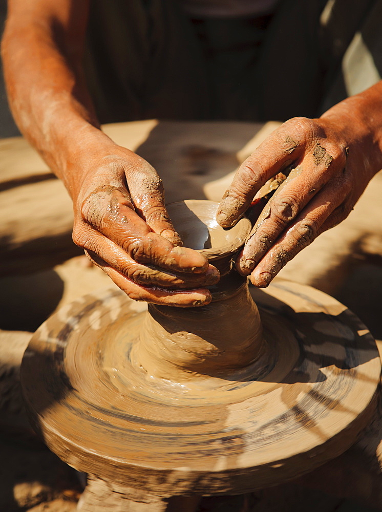 Local potter making earthenware pots on a hand driven wheel, Saijpur Ras, Gujarat, India, Asia