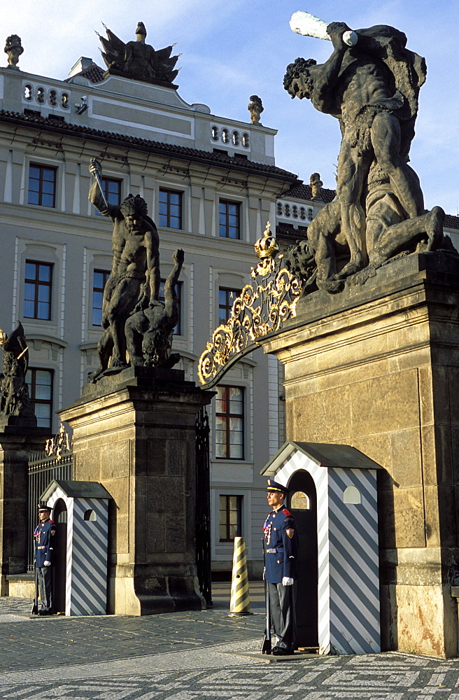 Two guards in front of the gate to Prague Castle, which has a titan statue on each of its two pillars, Hradcany, Prague, Czech Republic, Europe