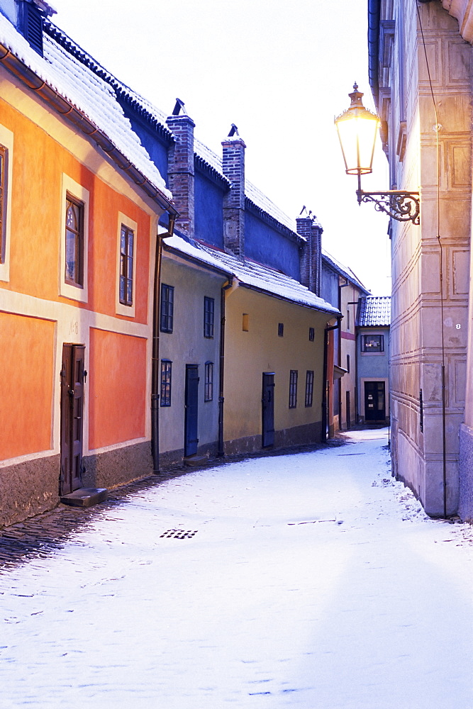 Snow covered 16th century cottages on Golden Lane (Zlata ulicka) in winter twilight, Hradcany, Prague, Czech Republic, Europe