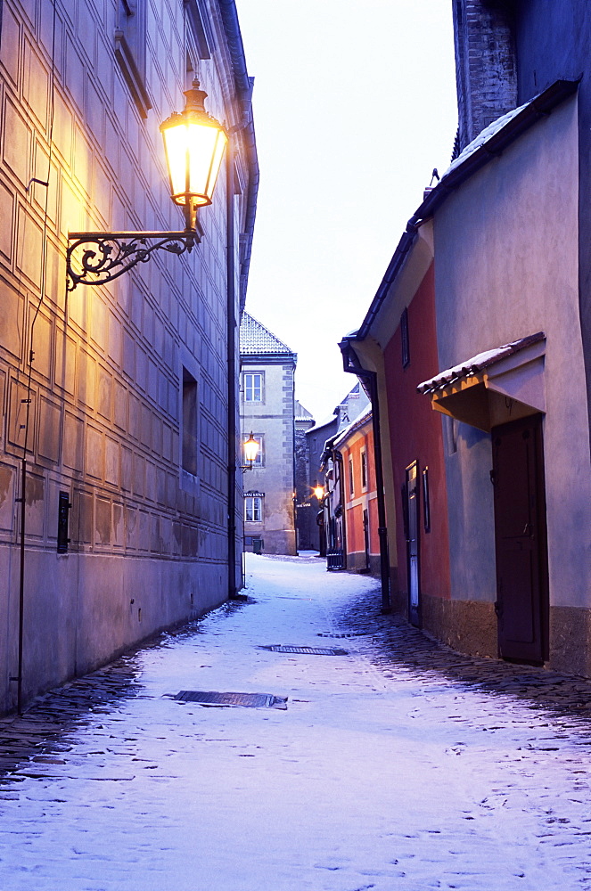 Snow covered 16th century cottages on Golden Lane (Zlata ulicka) in winter twilight, Hradcany, Prague, Czech Republic, Europe