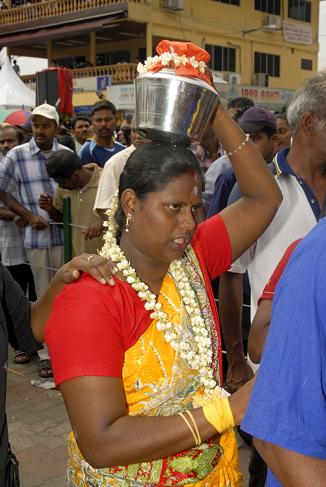 Pilgrim known as kavadi carrier is carrying container (paal kudam) of milk offerings during Hindu Thaipusam Festival from Sri Subramaniyar Swami Temple to Batu Caves, Selangor, Malaysia, Southeast Asia, Asia