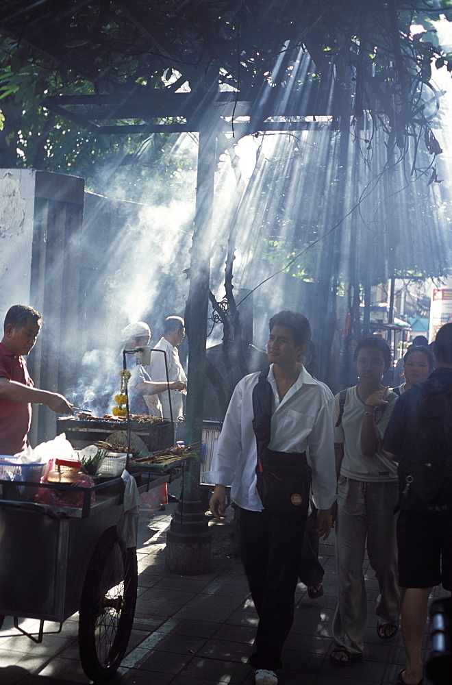 Street vendors selling grilled meat to passers-by on train platform, Bangkok, Southeast Asia, Thailand, Asia