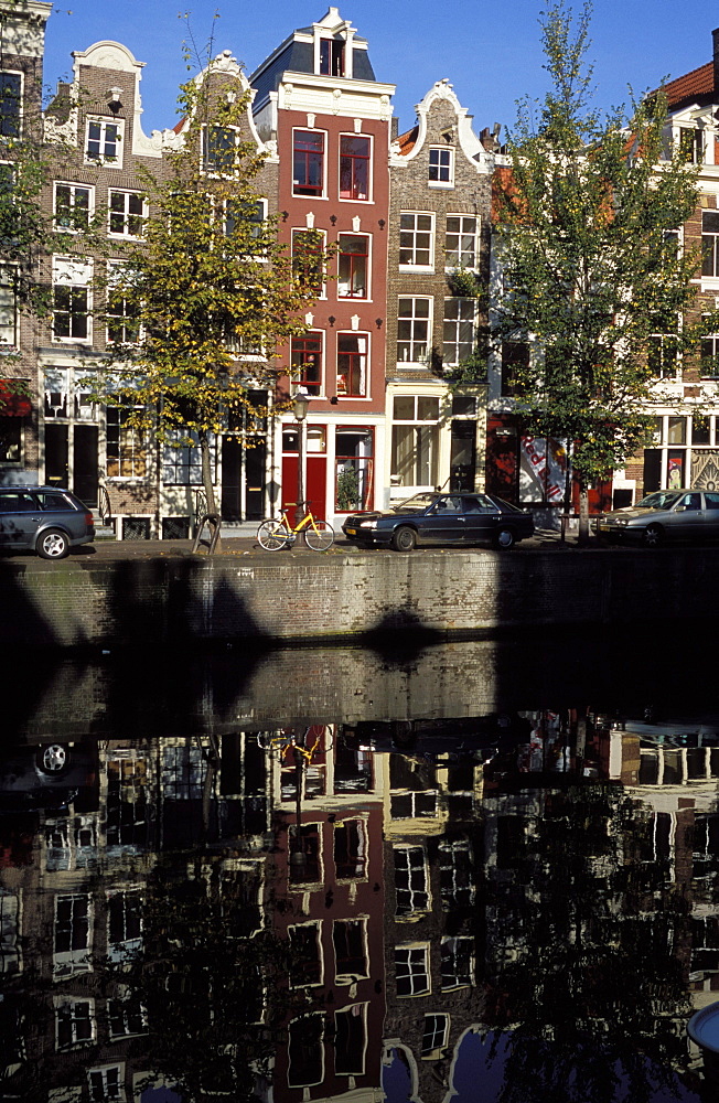 Tall traditional style houses reflected in the water of a canal, Amsterdam, The Netherlands (Holland), Europe